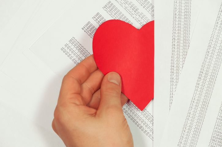 B2B emotional buying: red paper heart being tucked between data printouts