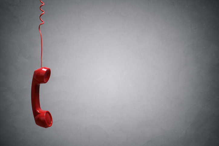 mentoring remote employees: red telephone hanging by telephone cord