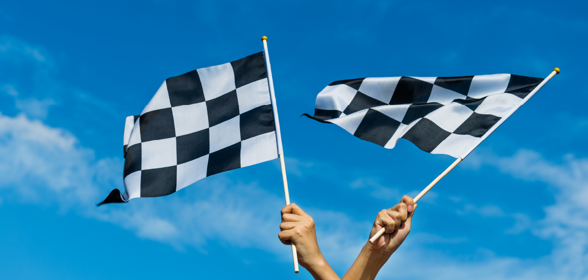 Ask the Experts: How to Wrap Up a Project on the Right Foot - two hands holding checkered flags at the finish line